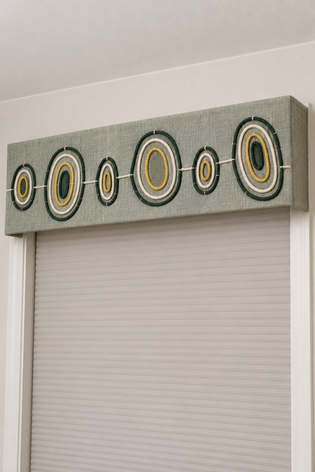 Sage fabric window pelmet with repeated cream, mustard and dark green oval motifs