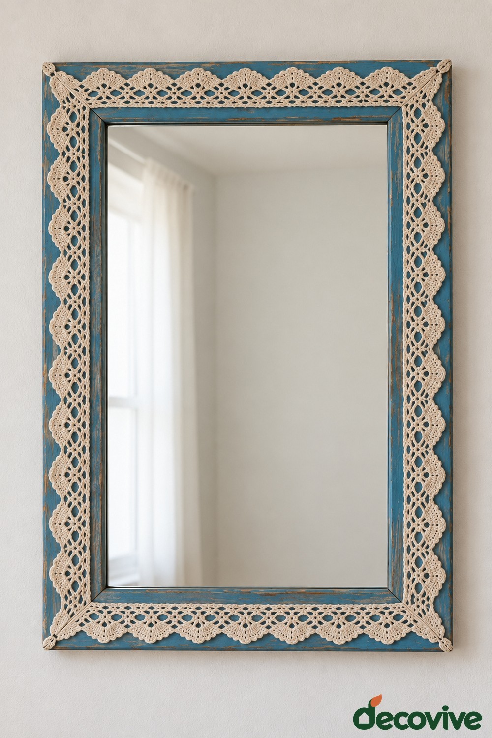 Rectangular blue mirror frame with cream lace trim around all four sides