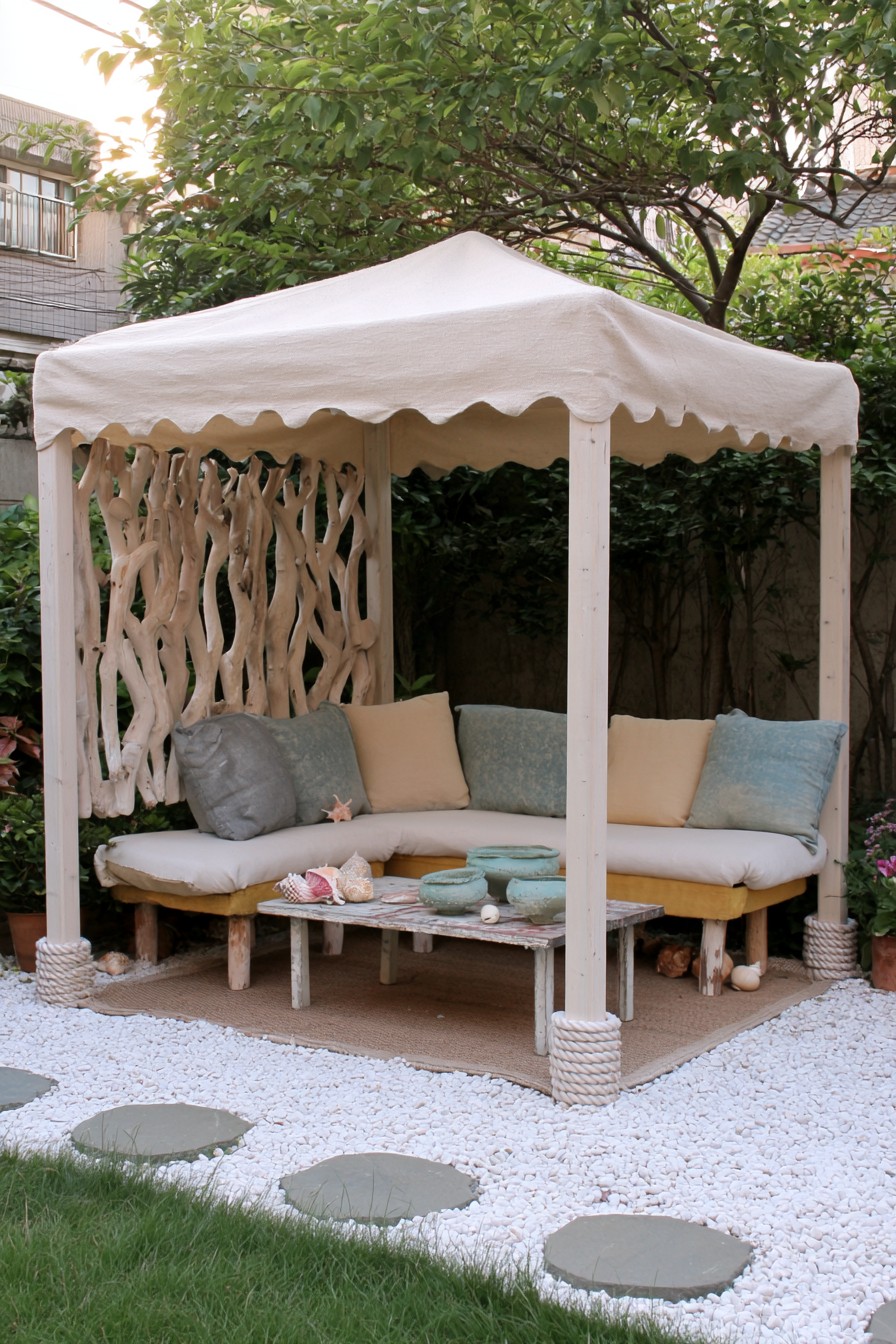 Pale canopy over a coastal corner lounge with a branch screen and muted cushions