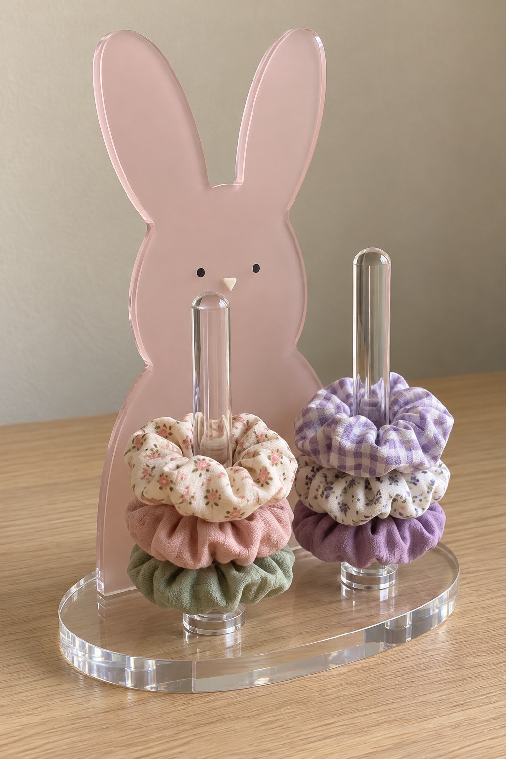 Blush acrylic bunny scrunchie stand with two clear upright rods on an oval base