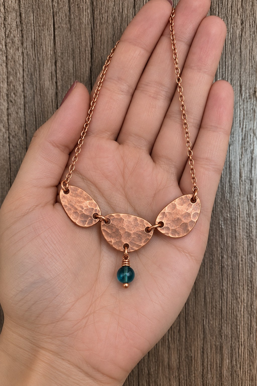 Necklace with three rounded hammered copper plates and one teal bead drop