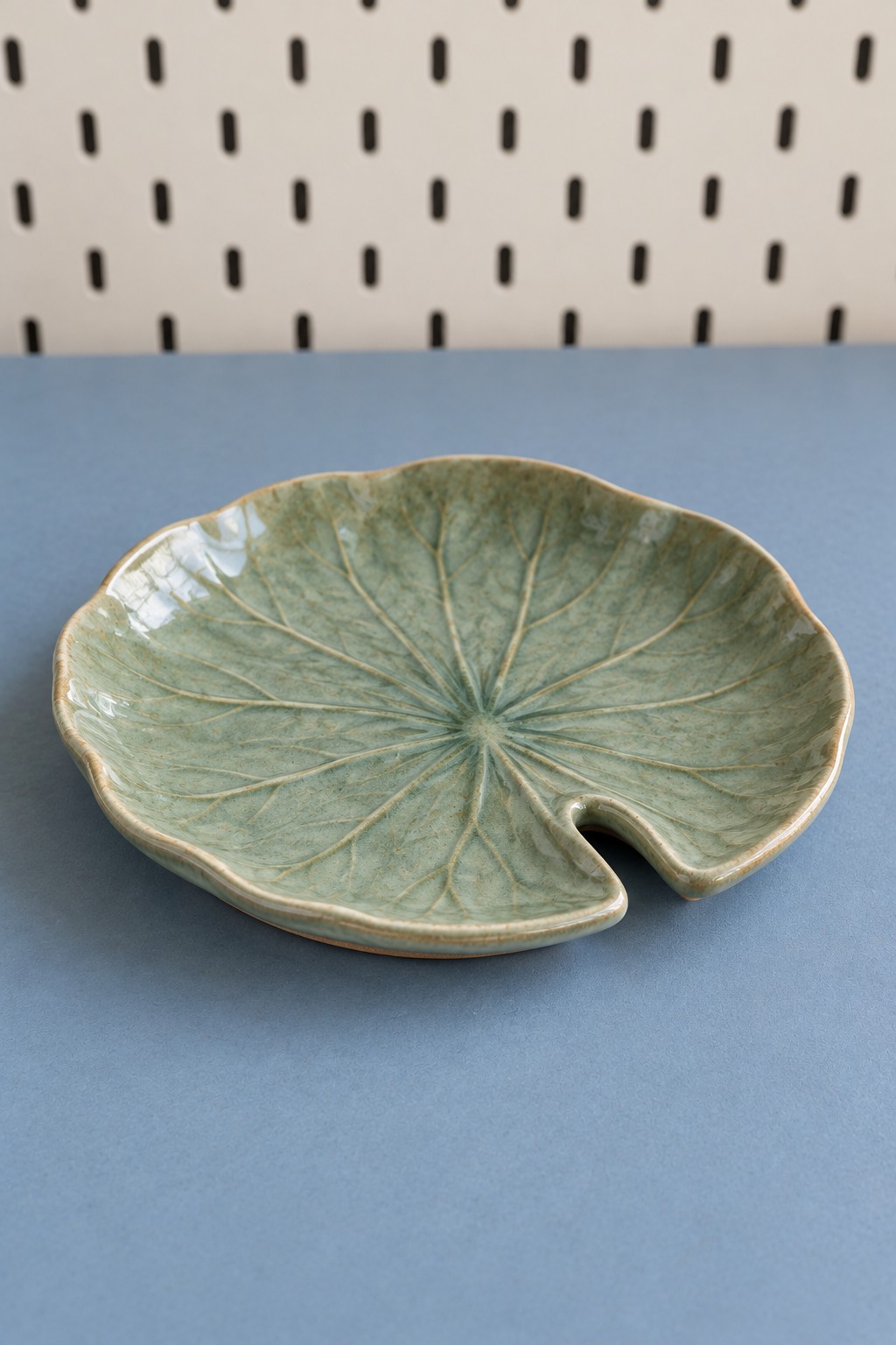 Shallow green decorative clay dish with radiating leaf veins and a stem notch