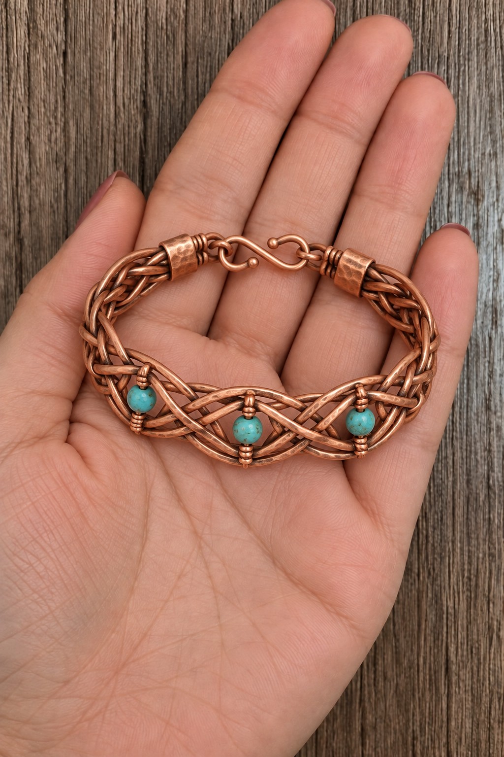 Interlaced copper wire bracelet with three turquoise colored beads and a hook clasp