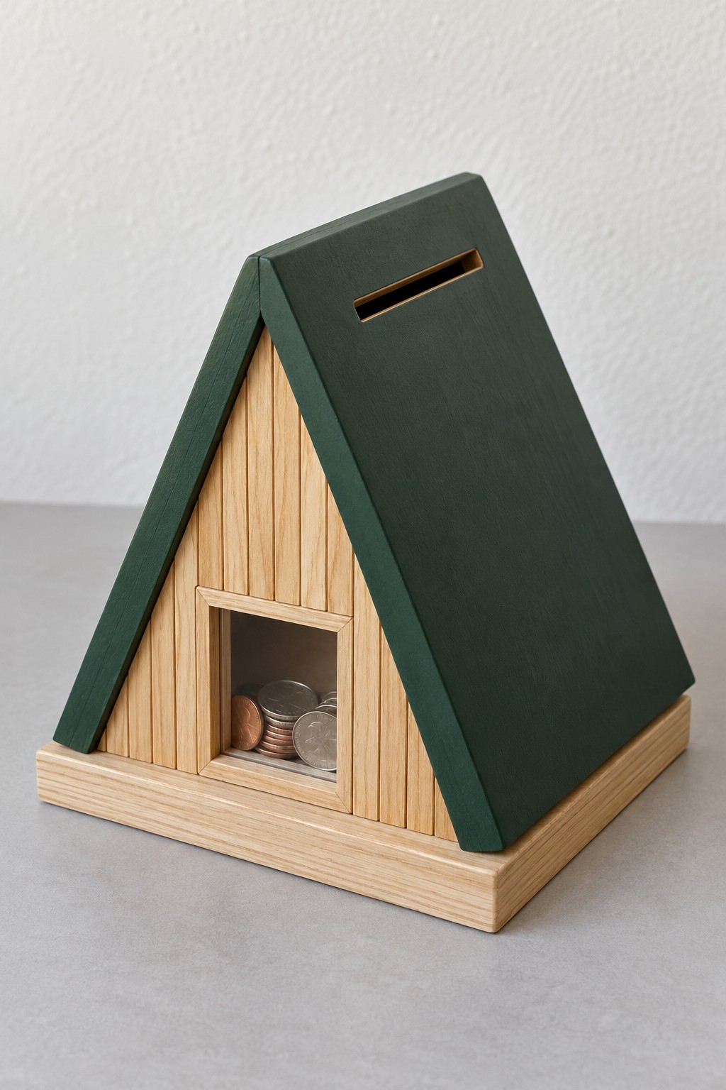 Triangular wooden cabin bank with dark green roof and a square clear savings window
