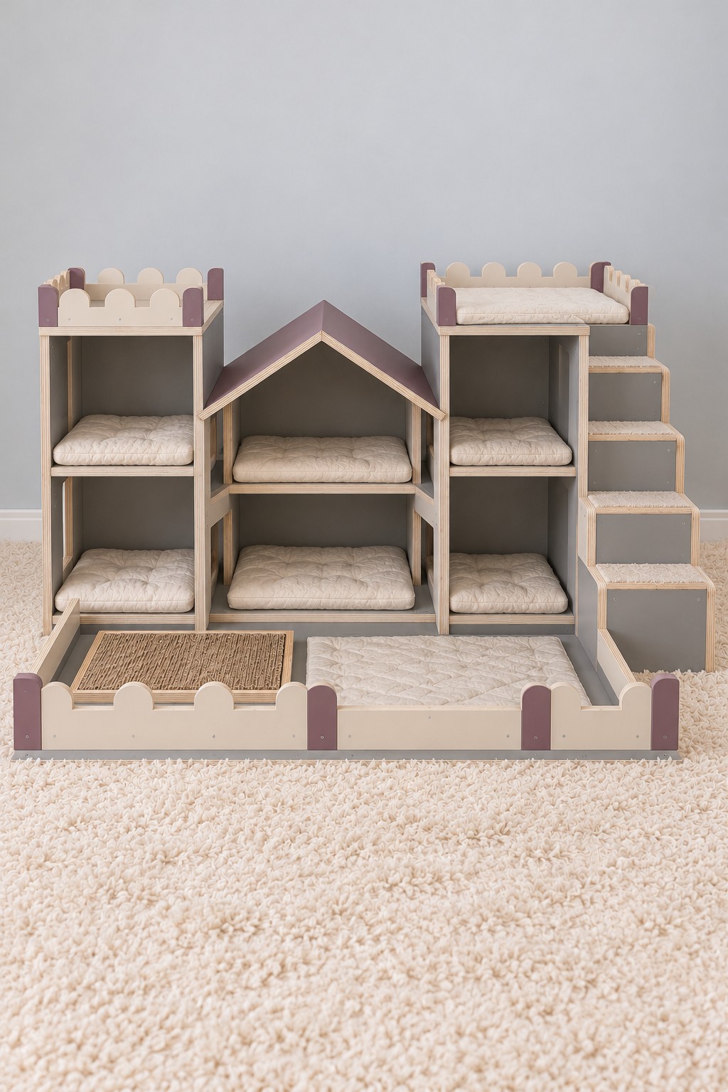 Cream and mauve cat castle with six cushioned cubbies, right side stairs, and a low front scratching courtyard
