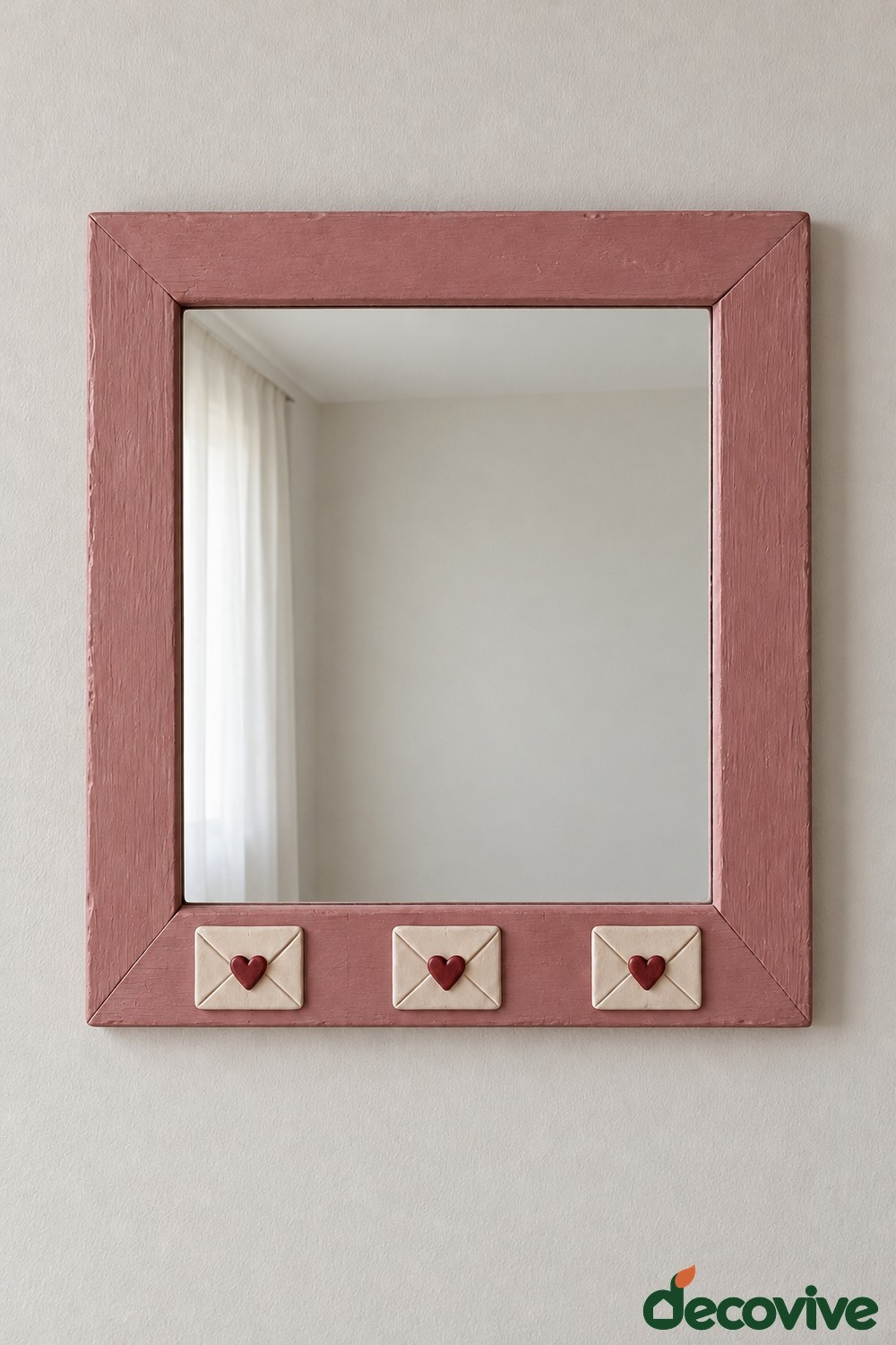 Dusty rose rectangular mirror with three cream miniature clay envelopes and burgundy hearts along the bottom