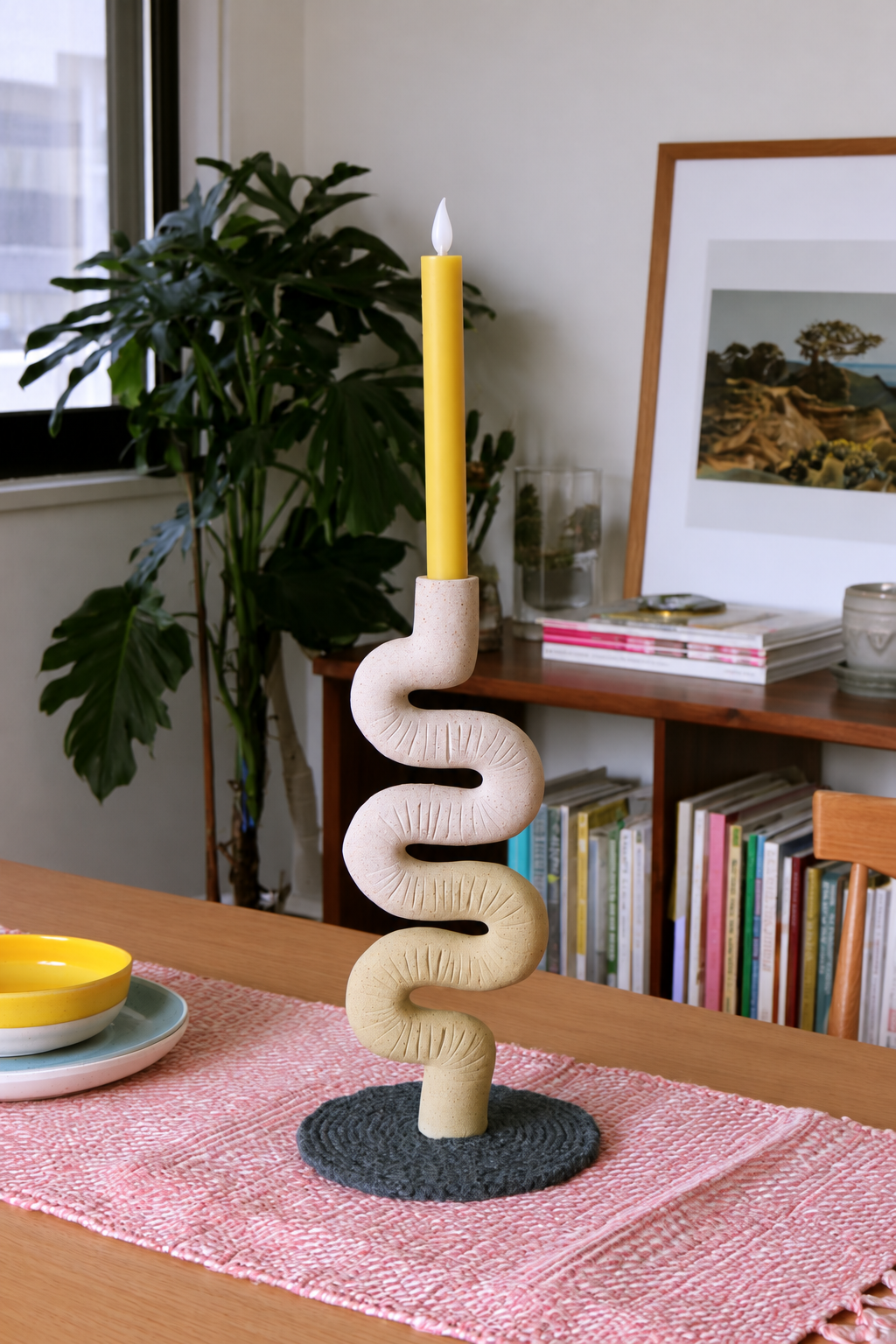 Wavy pink and pale yellow clay holder with a flameless yellow taper