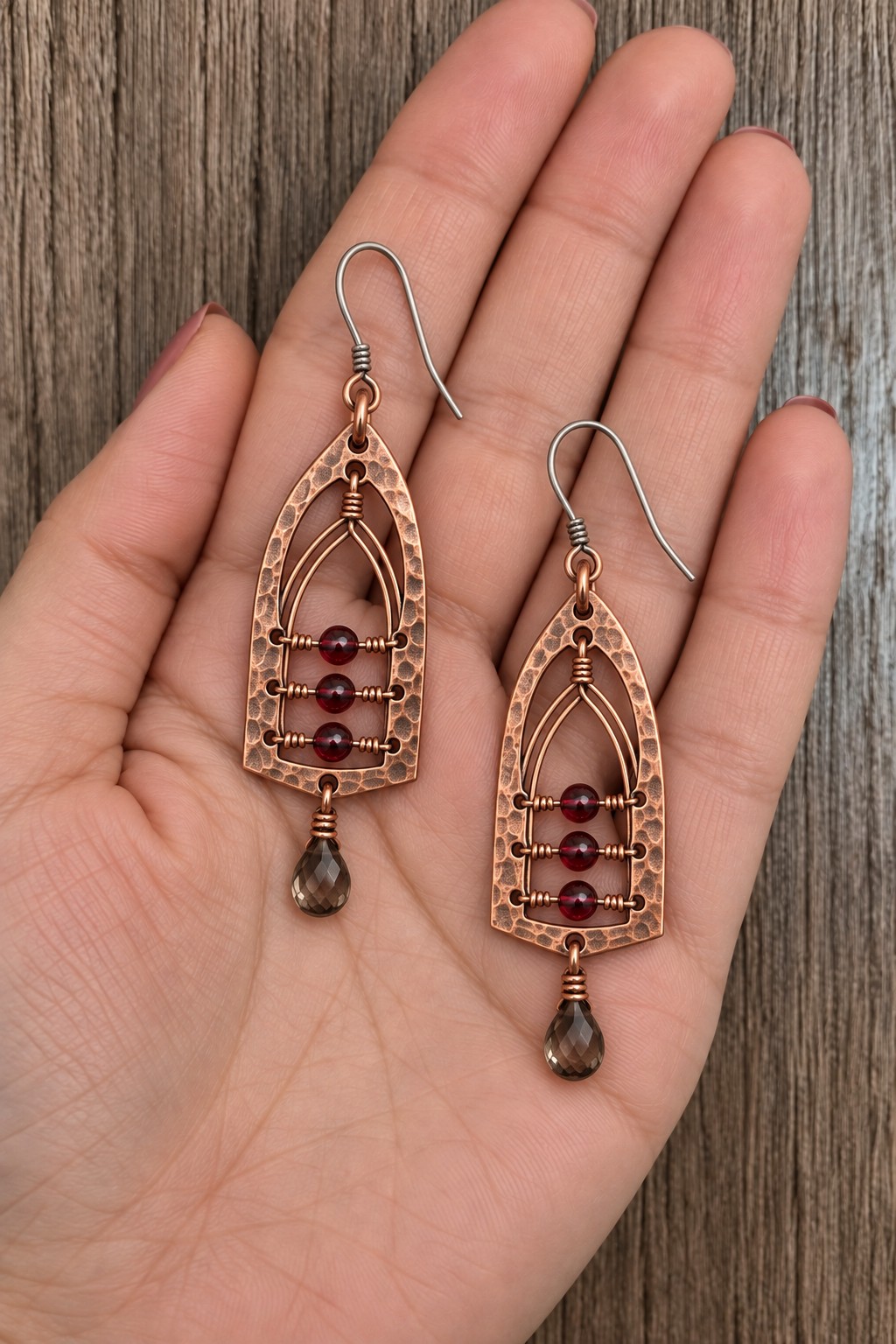 Pointed arch copper earrings with fine inner arches, three burgundy beads, and smoky drops