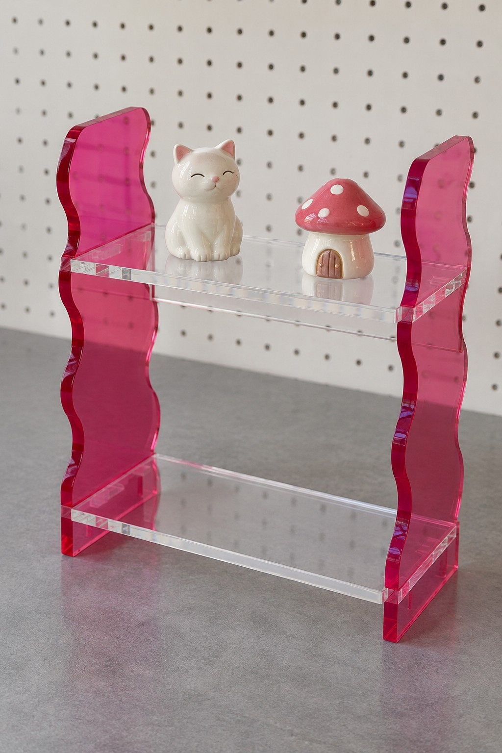 Small two level clear acrylic display shelf with magenta wavy side panels