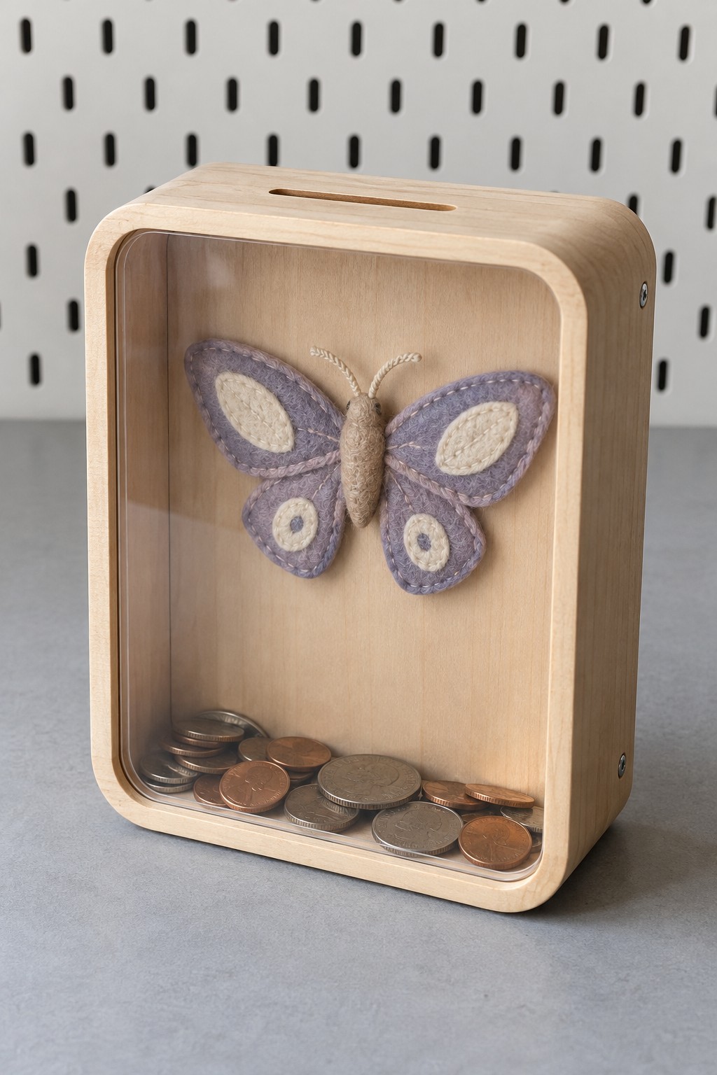 Rounded rectangular wood coin bank with a clear front and a stitched lavender butterfly on its backing