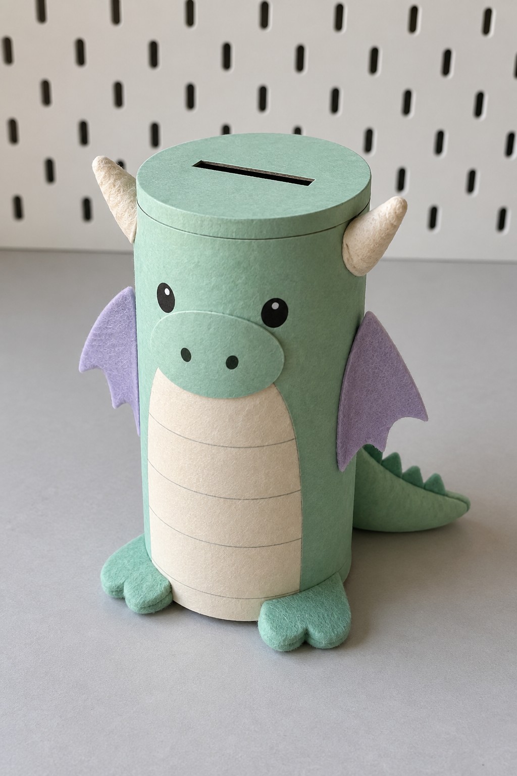 Mint green dragon coin bank with a cylindrical body, cream belly, pale horns and lavender wings