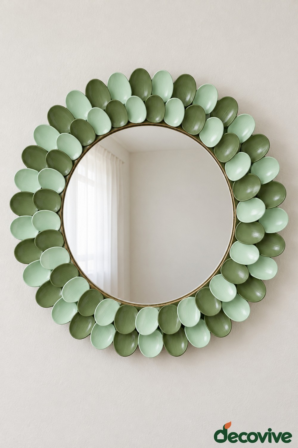 Round mirror surrounded by overlapping green painted plastic spoon bowls