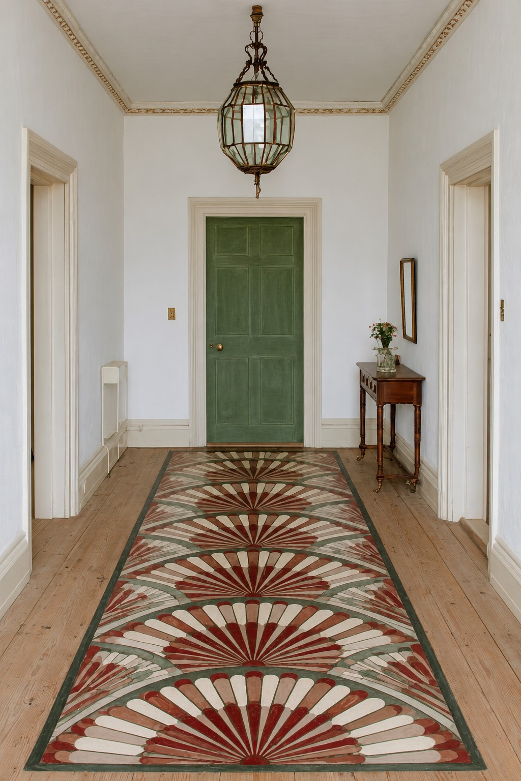 Terracotta, green, cream, and brown fan shapes forming a bordered runner along a wooden hallway