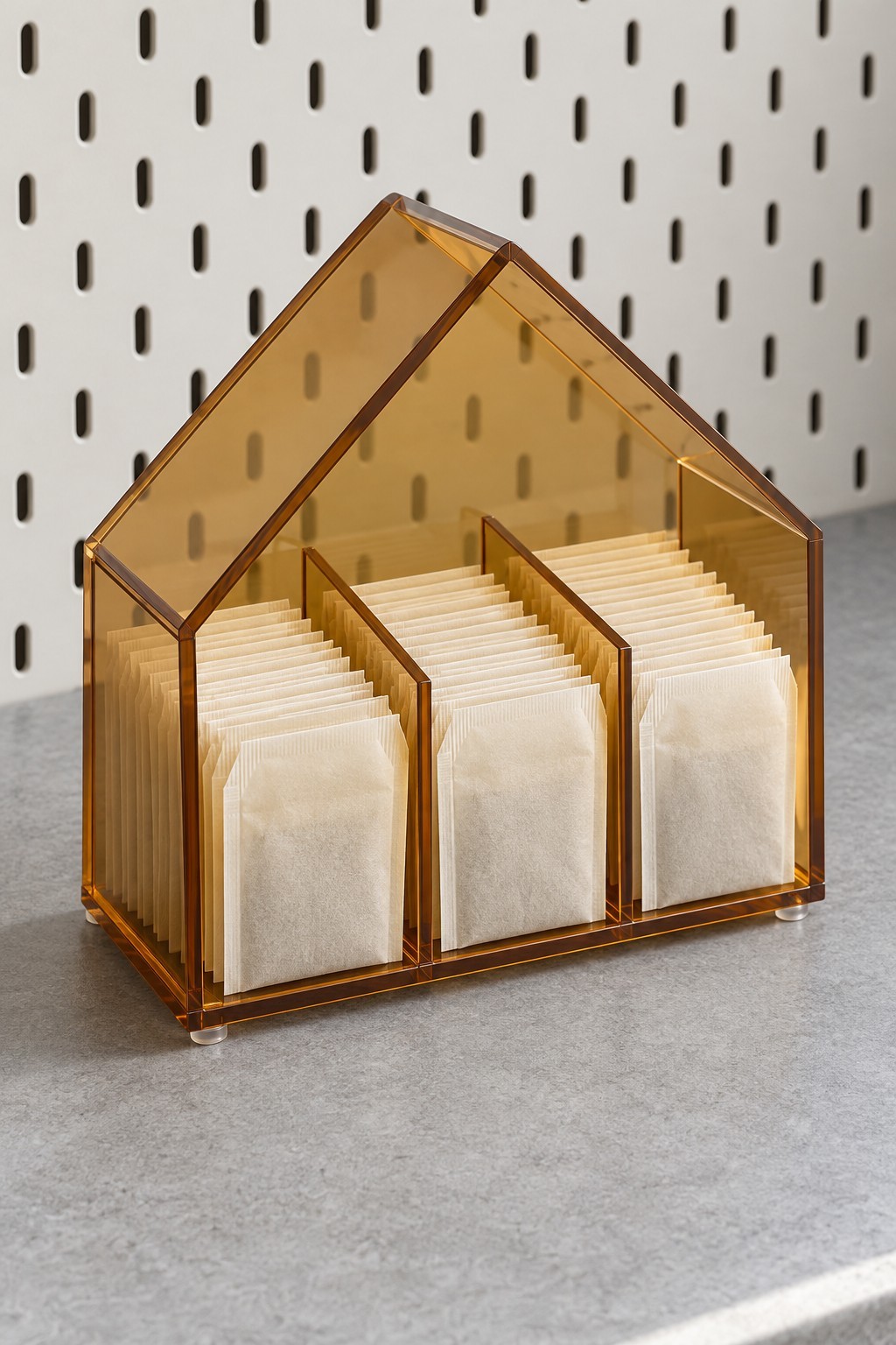 Amber acrylic house organizer with three divided rows of tea sachets