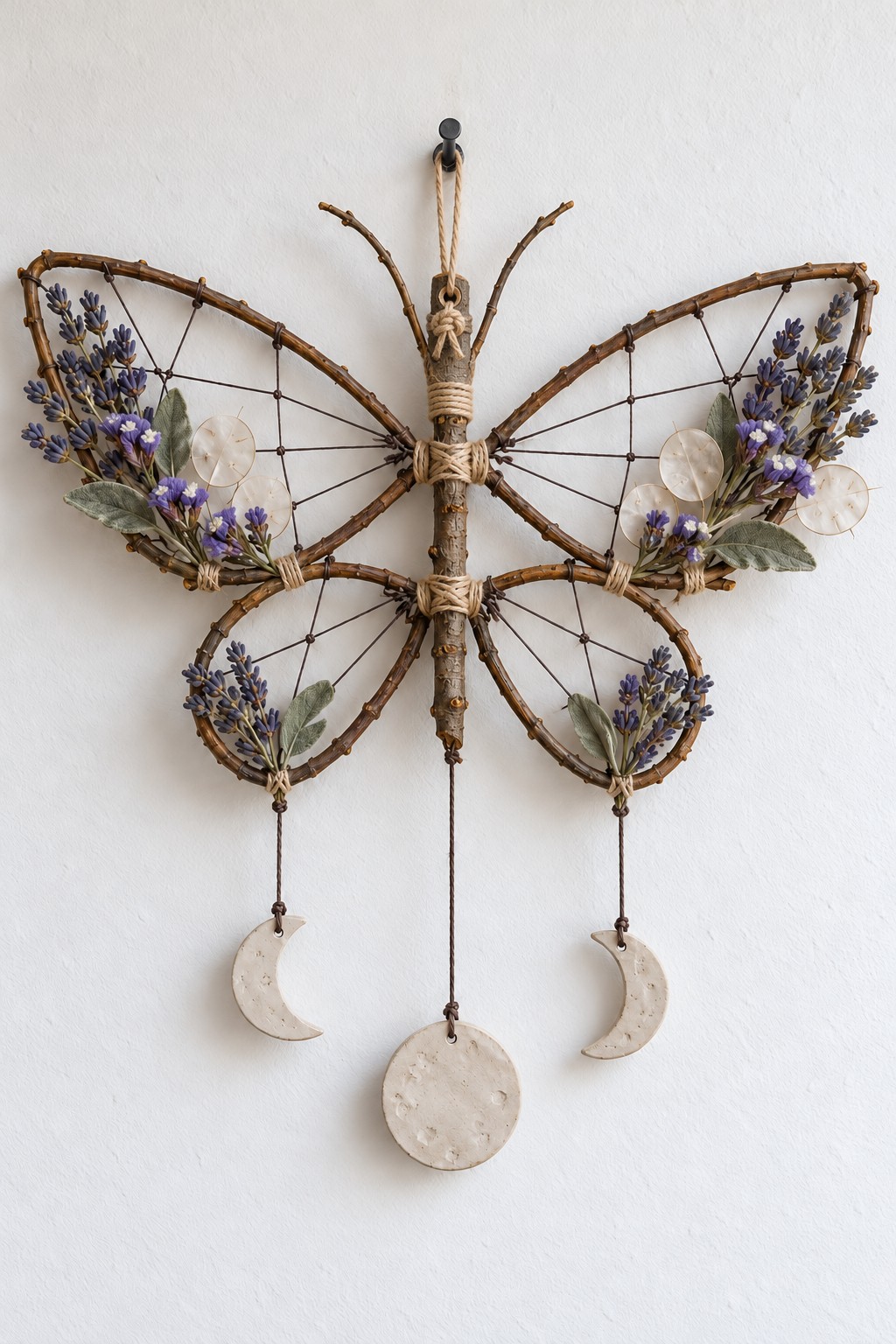 Wing shaped twig hanging with lavender, open cord webs, two crescent charms and a round moon charm