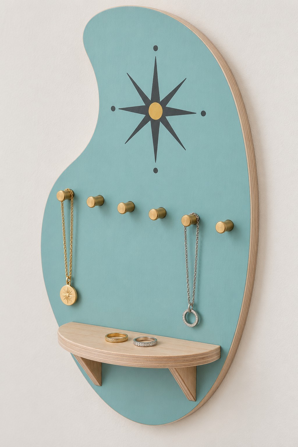 Asymmetric turquoise wall jewelry organizer with a starburst, brass pegs and a curved shelf