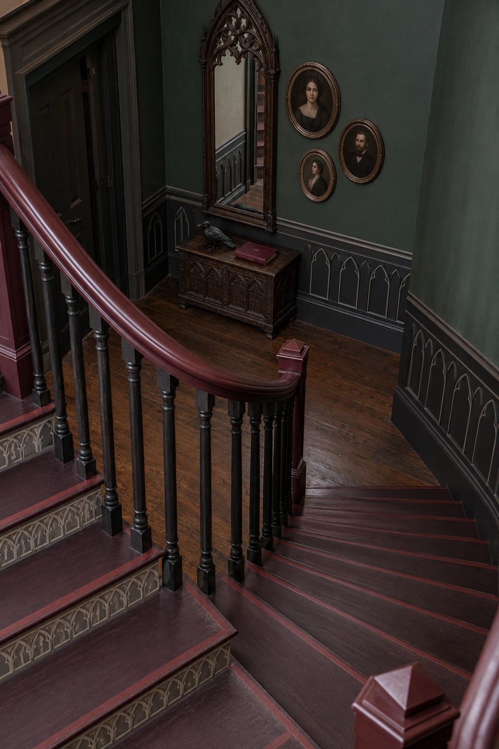 Dark wood toned stairs with wine colored borders, black spindles, green walls, and a pointed mirror