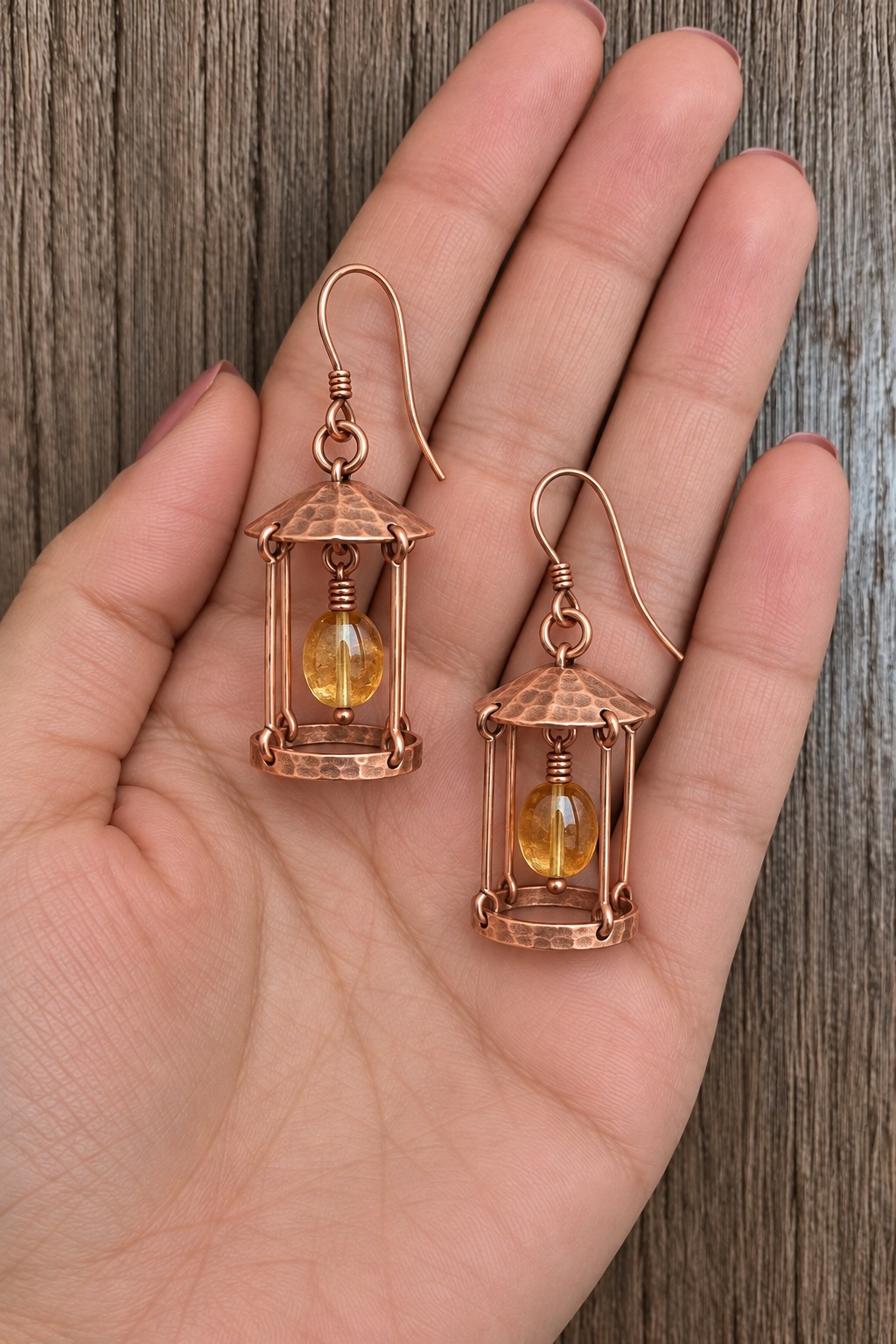 Pair of miniature copper lantern earrings with domed roofs and golden oval beads inside