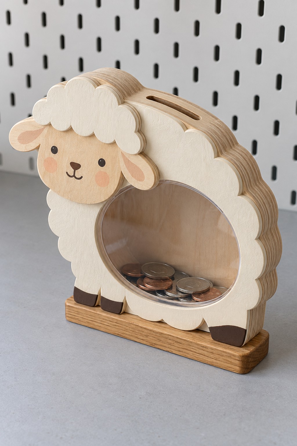 Layered wooden sheep coin bank with a white scalloped outline, clear round belly and natural wood stand