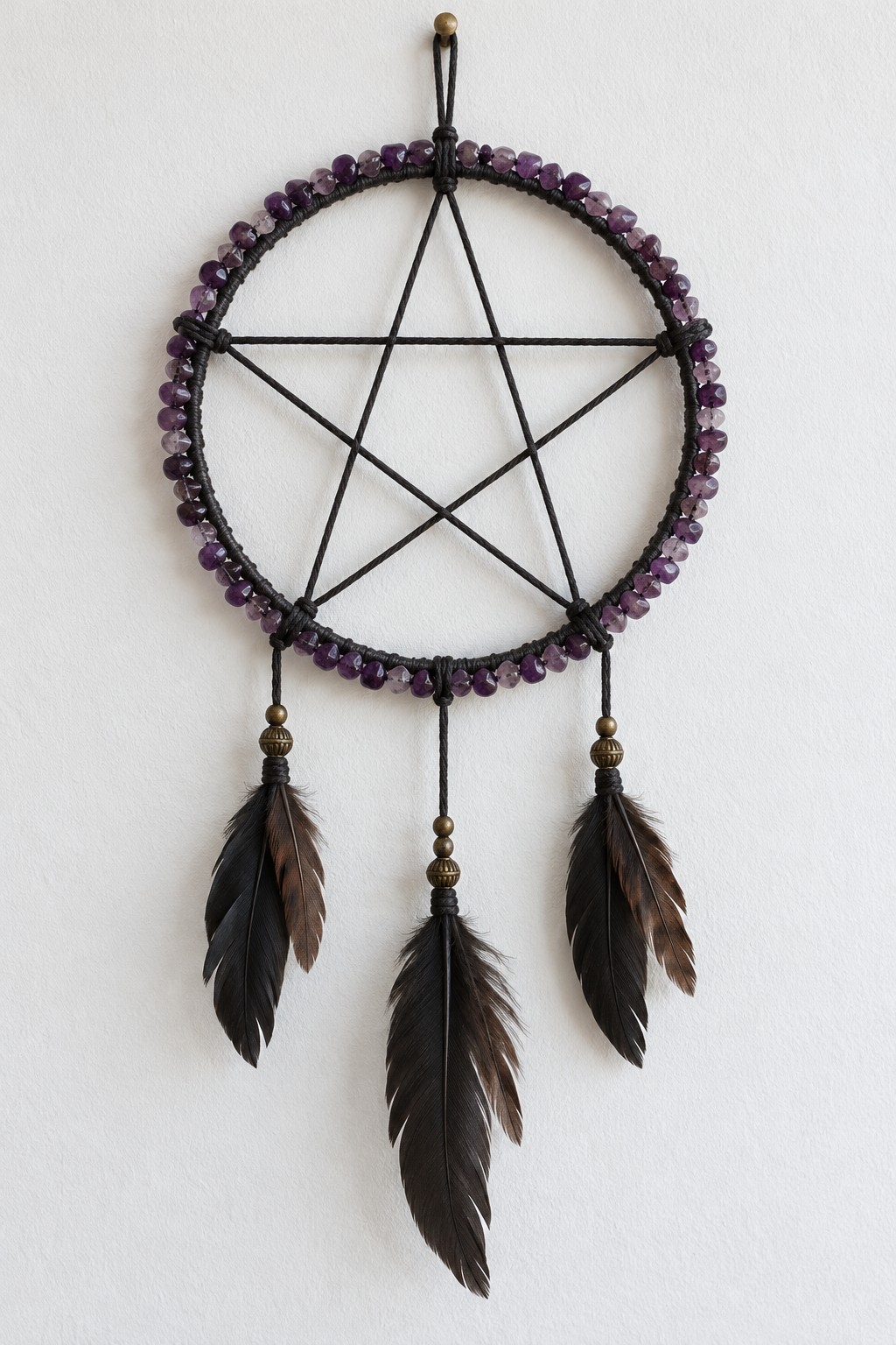Circular black pentagram hanging edged with purple stone chip beads and finished with three dark feathers