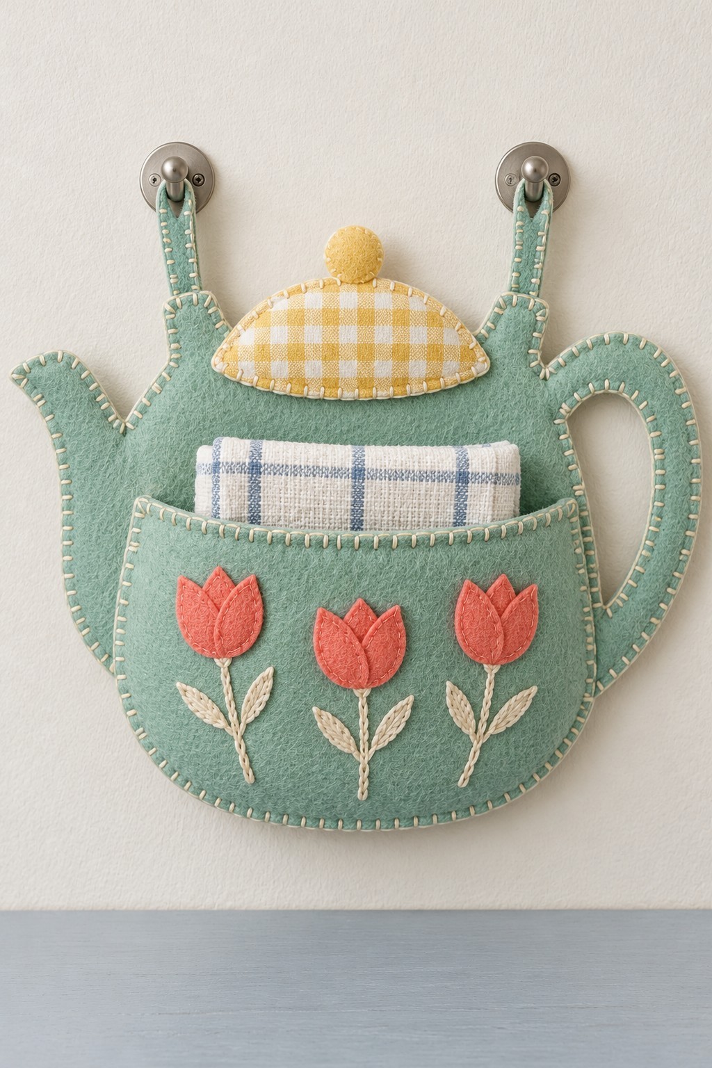 Sage felt teapot wall pocket with coral tulips, a yellow checked lid and two hanging loops