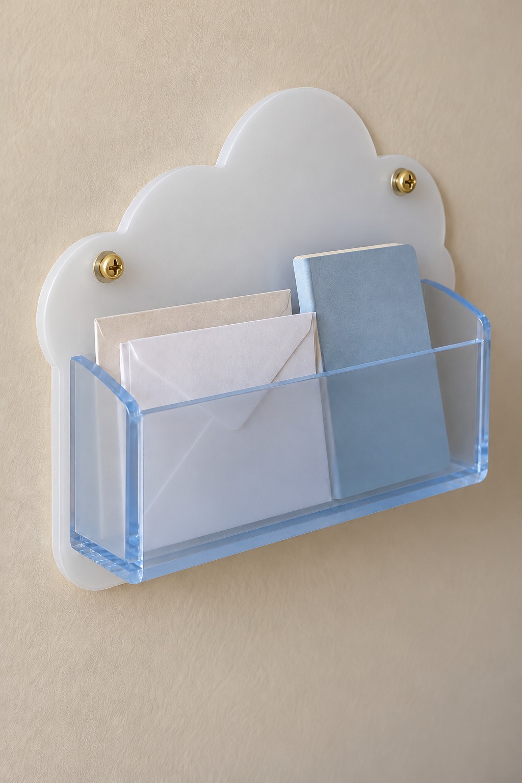 White cloud acrylic wall organizer with a pale blue pocket for envelopes and a notebook