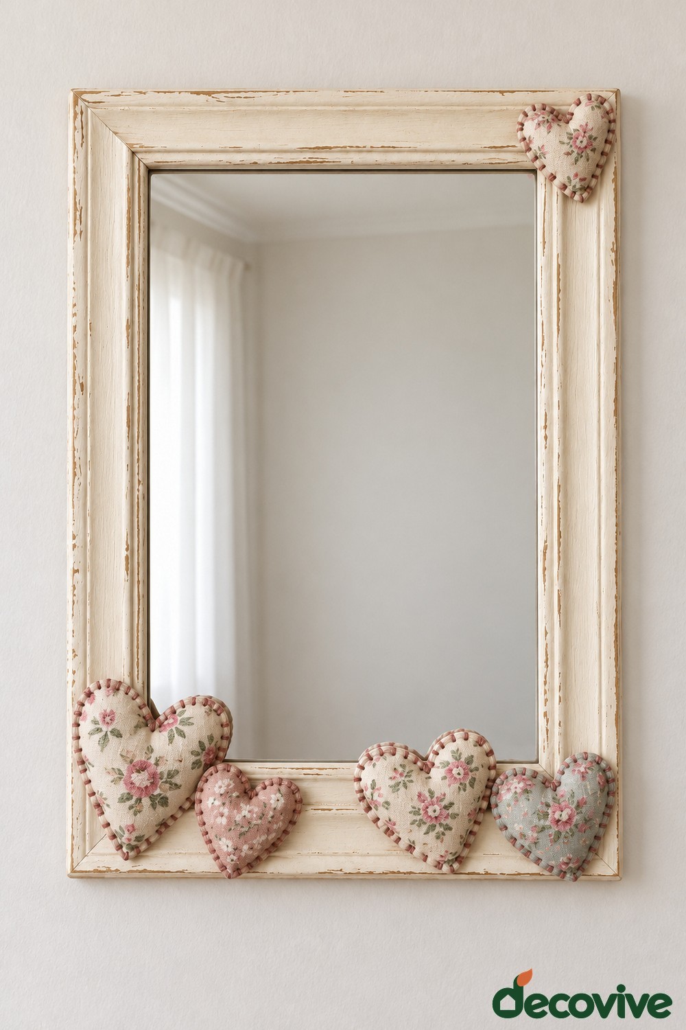 Cream rectangular mirror with small stuffed floral fabric hearts at the corners and along the bottom